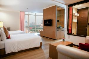 a hotel room with a bed and a television at The Berkeley Hotel Pratunam in Bangkok