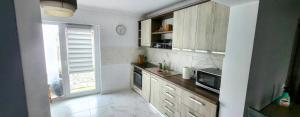 a kitchen with wooden cabinets and a microwave at Casa de inchiriat in Oradea