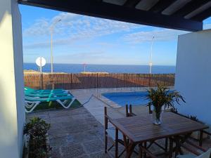 a patio with a table and a view of the ocean at Villa Victor in Cala en Blanes