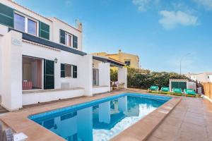 a villa with a swimming pool in front of a house at Villa Victor in Cala en Blanes