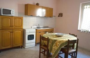 a kitchen with a table and a white stove top oven at Loiacono Apartments 2 in Caria