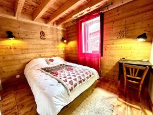 a bedroom with a bed in a wooden cabin at Maison Boule de Neige, meublé de tourisme 3 étoiles in Formiguères