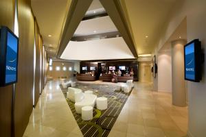 - un hall d'un hôtel avec des chaises blanches dans l'établissement Novotel Brisbane Airport, à Brisbane