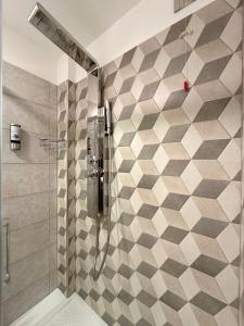 y baño con ducha y pared de azulejos. en BB Nuova Villa Paradiso, en Urbino