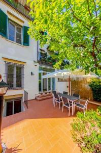 un patio avec une table, des chaises et un parasol dans l'établissement Private Oasis Home with outdoor Piazza Libertà, à Florence