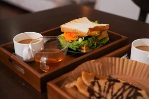 a tray with a sandwich and two cups of coffee at The Upper House Sapa in Sapa