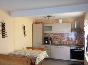 a kitchen with white cabinets and a table in it at Bungalow Mechow in Mechow