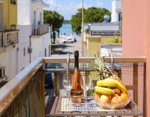 a basket of fruit and a bottle of wine on a balcony at Belvedere Luxury Seafront With Panoramic Terrace in Porto Cesareo