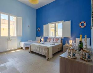 a bedroom with two beds and blue walls at Belvedere Luxury Seafront With Panoramic Terrace in Porto Cesareo