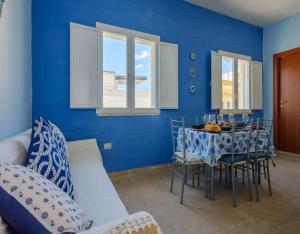 a dining room with blue walls and a table and chairs at Belvedere Luxury Seafront With Panoramic Terrace in Porto Cesareo +33 photos