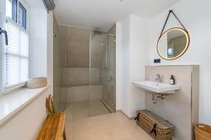 a bathroom with a shower and a sink and a mirror at Haus Marit in Westerland +38 photos