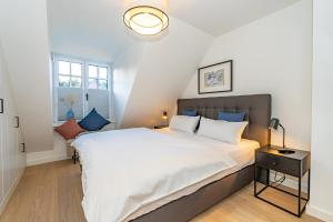 a bedroom with a large white bed with blue pillows at Haus Marit in Westerland