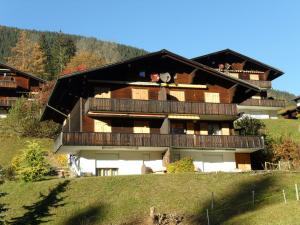 un gran edificio con balcón en una colina en Apartment Grindelwaldgletscher - GRIWA RENT AG, en Grindelwald