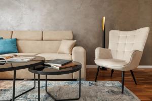 a living room with a couch and a table and a chair at Warm Amber Suites Brașov in Braşov