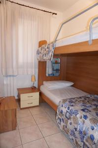 sypialnia z dwoma łóżkami i łóżkiem piętrowym w obiekcie Comfortable flat with pool - Beahost w mieście Porto Santa Margherita di Caorle