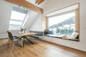 a dining room with a table and a large window at Arton Lachtal - Apartments Steiermark in Lachtal