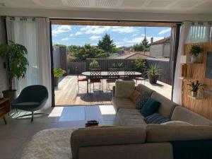 salon z kanapą i patio w obiekcie Maison avec piscine à 10 min du centre de Bordeaux w mieście Bègles