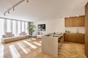 a kitchen and living room with a couch and a table at The Samirah Luxury Residences in Elliniko in Athens