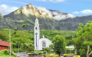 a white church with a mountain in the background at Maison accueillante à Cilaos avec vue sur la montagne in Cilaos