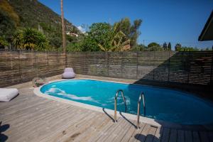 Spa Villa Skaloma في نافباكتوس: مسبح صغير ذو سطح خشبي وجدار من الطوب