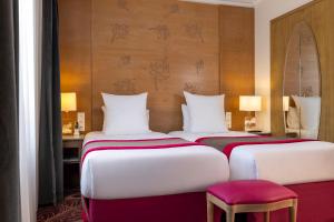 two beds in a hotel room with at Hotel Muguet in Paris +29 photos