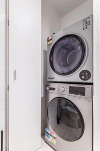 a microwave and a washing machine in a room at VAQUAY Fifth Avenue In Melbourne CBD in Melbourne