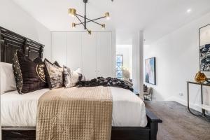a bedroom with a large bed with brown pillows at VAQUAY Fifth Avenue In Melbourne CBD in Melbourne