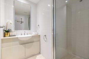 a white bathroom with a sink and a shower at VAQUAY Fifth Avenue In Melbourne CBD in Melbourne +24 photos