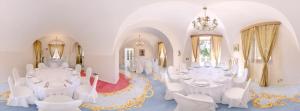 a ballroom with white tables and chairs and a chandelier at Affittacamere Villa Gigli in Sirolo
