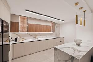 une cuisine blanche avec un évier et un comptoir dans l'établissement Luxury 3 BDR In The Heart Of Jerusalem By Isrentals, à Jérusalem 68 autres photos