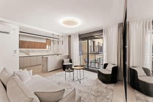 un salon avec un canapé et des chaises et une cuisine dans l'établissement Luxury 3 BDR In The Heart Of Jerusalem By Isrentals, à Jérusalem