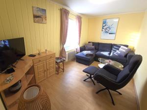 Una sala de estar con un sofá y un televisor. en Bungalow Wiesenperle, en Trassenheide