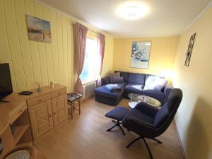 una sala de estar con un sofá y una mesa en Bungalow Wiesenperle, en Trassenheide
