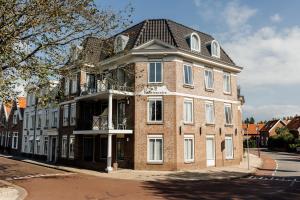 a large brick building with a gambrel roof at B's Strandappartementen in Domburg