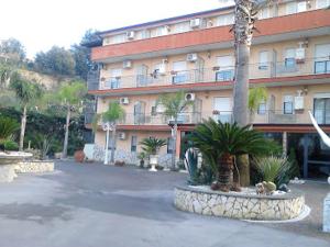 a large building with palm trees in front of it at Hotel Happy Days in Licola