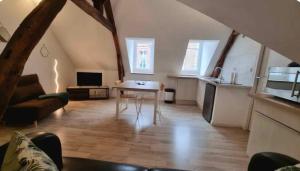 a living room with a table and a kitchen at Le Musoir in Le Tréport