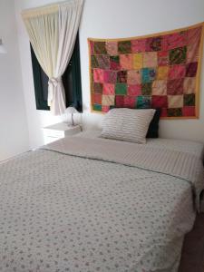 a bedroom with a bed with a quilt on the wall at Mairy's Ηouse in Alikí +40 photos