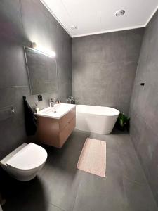 a bathroom with a tub and a toilet and a sink at Kolsåsbakken, Granåsen, Nordic Ski World Championships in Trondheim +9 photos