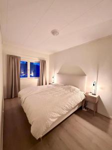 a white bedroom with a large bed and two windows at Kolsåsbakken, Granåsen, Nordic Ski World Championships in Trondheim