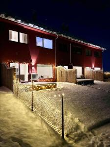 a house with a fence in the snow at night at Kolsåsbakken, Granåsen, Nordic Ski World Championships in Trondheim