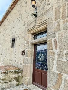 a brick building with a door with a stained glass window at Le Manoir médiéval de Garance in Châteaumur +58 photos