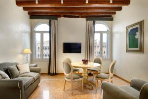a living room with a table and chairs at L'O Venezia Flat - WTB Hotels in Venice