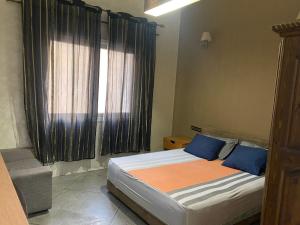 a bedroom with a bed with blue pillows and a window at Appartement en plein centre ville in Fès