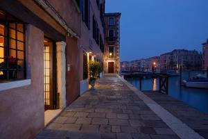 a city street with a canal at night at L'O Venezia Flat - WTB Hotels in Venice