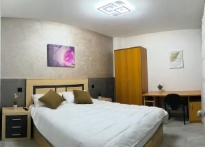 a bedroom with a white bed and a desk and a desk at Habitaciones Torija in Torija