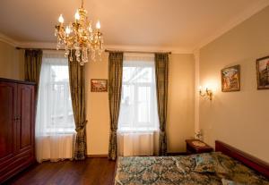 a bedroom with a chandelier and two windows at Lviv hollidays Galytska in Lviv