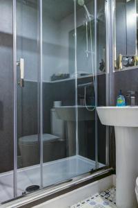 a bathroom with a shower with a sink and a toilet at No5 Ayr Beach - Coorie Doon Stays in Ayr +43 photos
