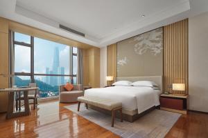 a bedroom with a large bed and a large window at Dongguan DongCheng International Hotel - Free shuttle buses for executive room guests during Canton Fair in Dongguan +43 photos