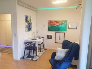 グリュックスブルクにあるModern und am Strand Balkon,PPのリビングルーム(テーブル、青い椅子付)