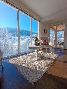 een woonkamer met een tafel en grote ramen bij Rest House in Olovo